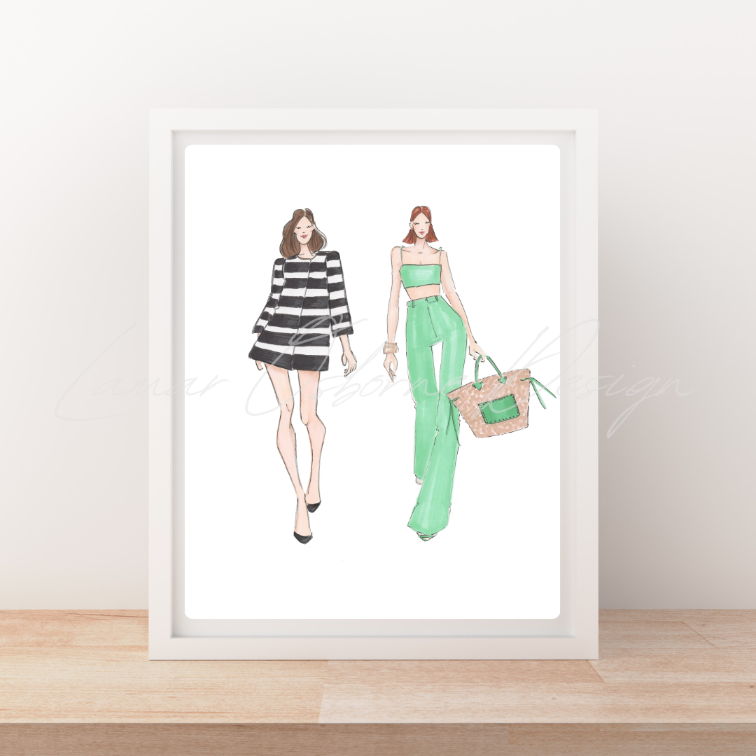 A framed fashion illustration print leaning against a wall on a light wood surface. The artwork shows two women in stylish outfits: one in a black-and-white striped dress and one in mint green pants with a matching crop top, holding a woven bag.